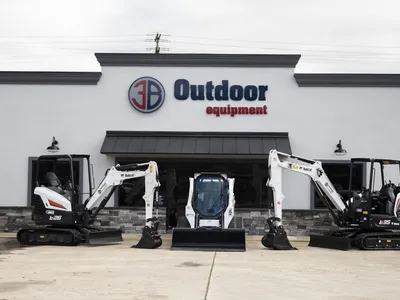 Showroom floor of 3B Outdoor Equipment displaying rows of premium lawn mowers with Hustler models prominently featured at...