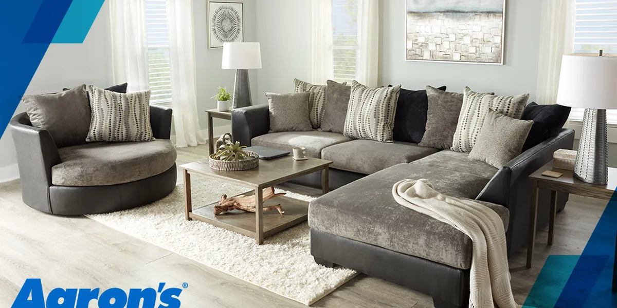 Showroom floor of Aaron's Rent To Own displaying furniture arrangements and home appliances with rental pricing signage...