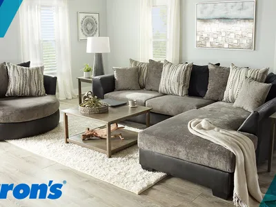 Showroom floor of Aaron's Rent To Own displaying furniture arrangements and home appliances with rental pricing signage...