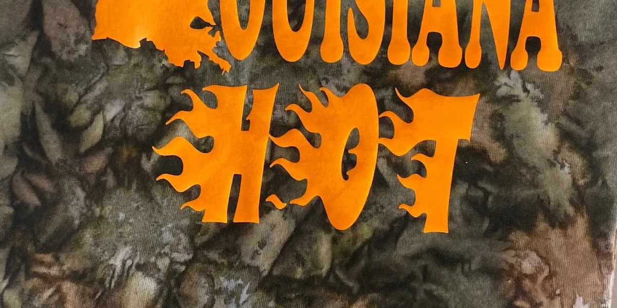 Compact gift shop displaying colorful Greek apparel and custom t-shirts with consultation space where Rick assists customers.