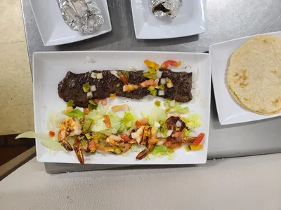 Cozy Latin American restaurant with homestyle cooking area, serving authentic Honduran dishes and café con leche in West...