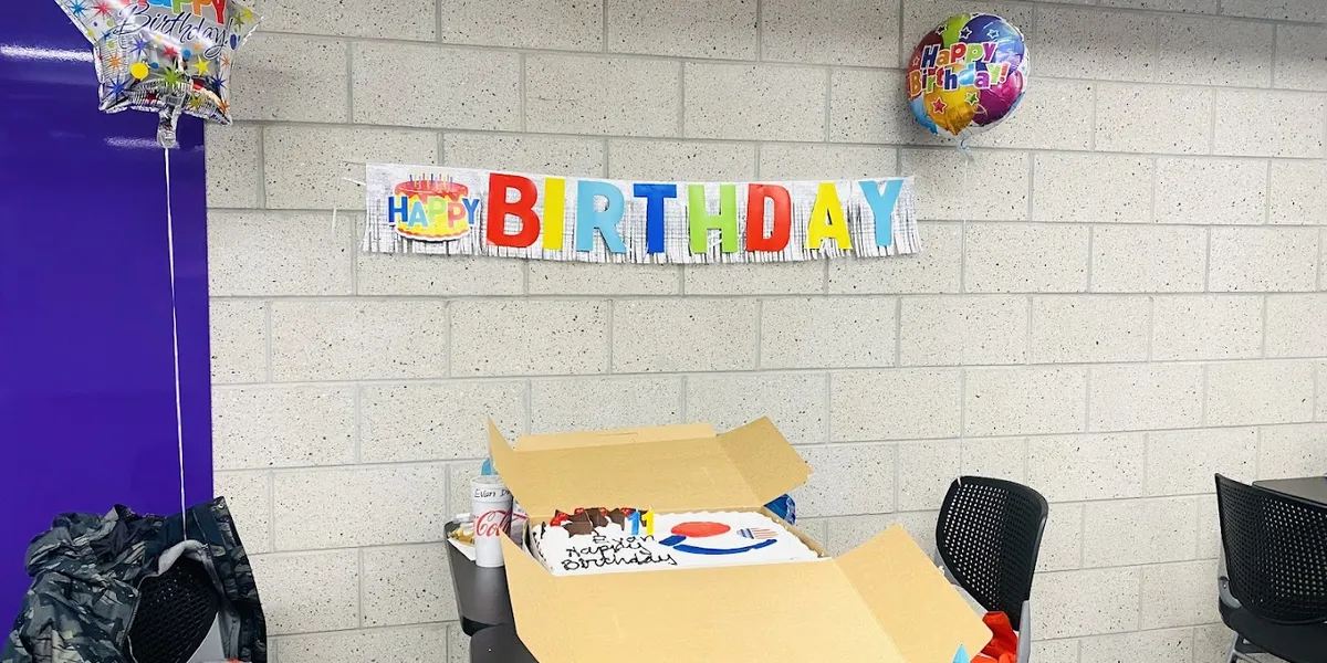 Custom-designed celebration cake with delicate gold accents and fresh berries at Allbritton's Cake House, showcasing...