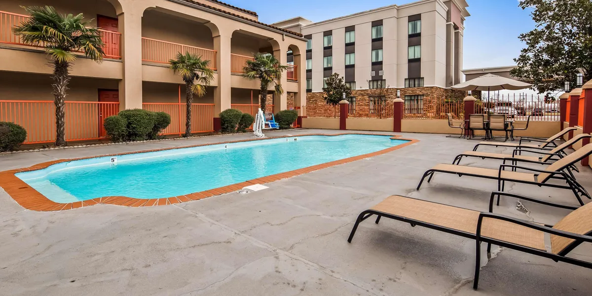 Roadside hotel with exterior corridor access, renovated rooms, and parking lot visible from Garrett Road near the highway.