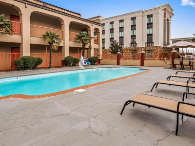 Roadside hotel with exterior corridor access, renovated rooms, and parking lot visible from Garrett Road near the highway.