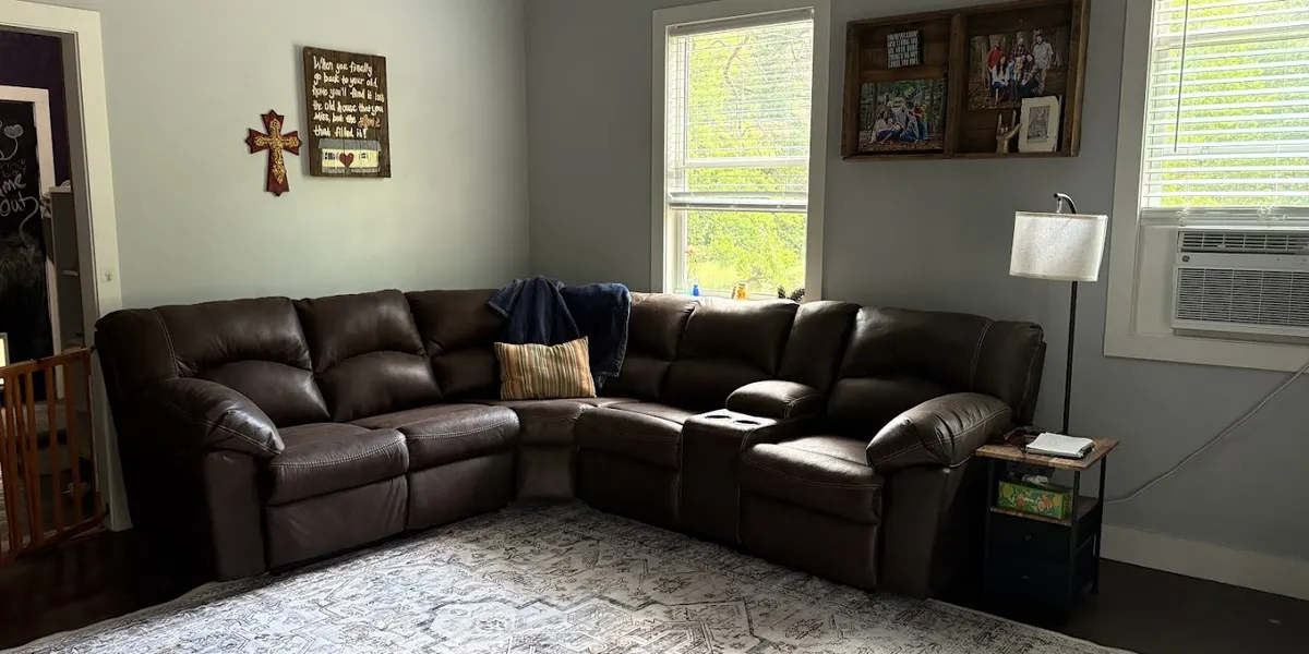 Spacious Ashley Outlet showroom displaying arranged living room furniture sets with clear pathways and attentive staff...