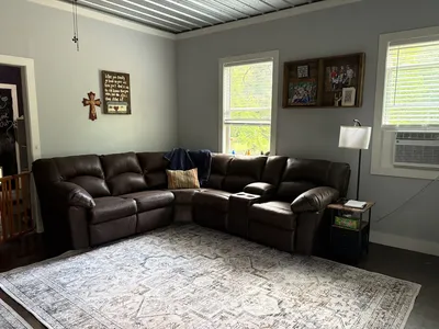 Spacious Ashley Outlet showroom displaying arranged living room furniture sets with clear pathways and attentive staff...