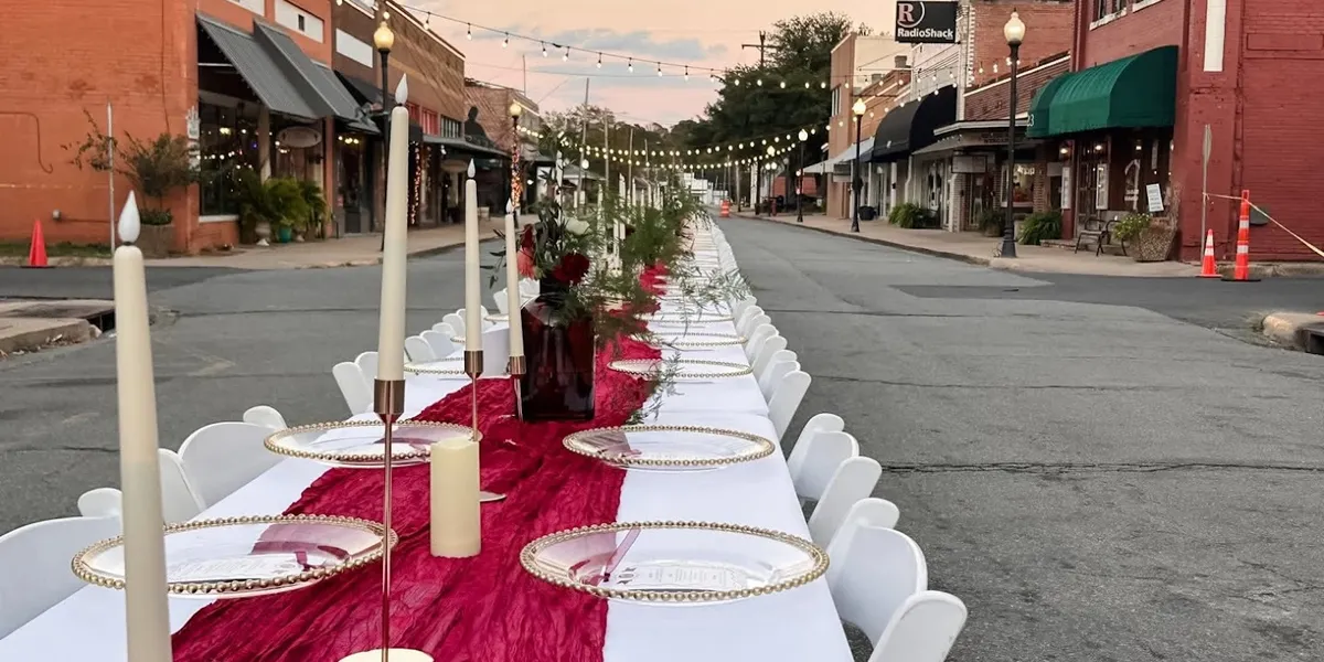 Colorful bouncy houses and neatly arranged event furniture at Bagby Rental's equipment yard, ready for delivery to West...