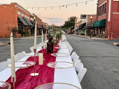 Colorful bouncy houses and neatly arranged event furniture at Bagby Rental's equipment yard, ready for delivery to West...