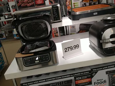 Interior of Belk department store showing clothing racks and merchandise displays in an open-format retail space with...