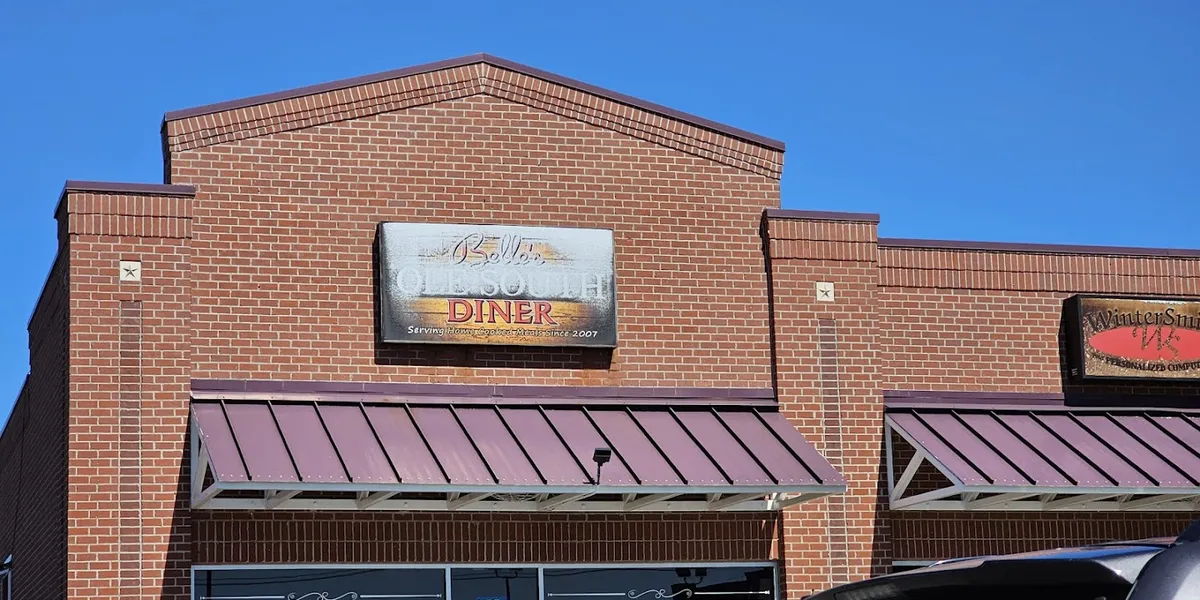 Bustling authentic Southern diner with tables of comfort food plates, friendly servers refilling drinks, and a crowd of...