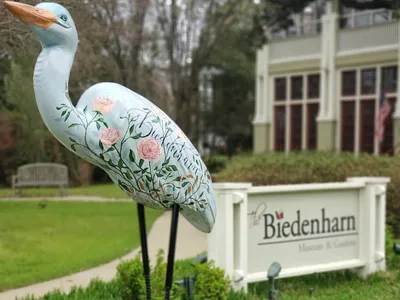 Elegant historic Biedenharn home with sprawling gardens featuring tree-sized plants and Coca-Cola memorabilia displays...