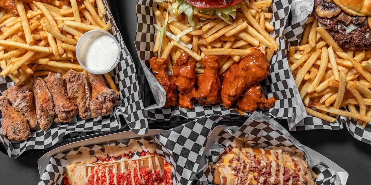 Casual bar with outdoor seating serving signature smash burgers and wings, featuring a relaxed atmosphere for dining and...