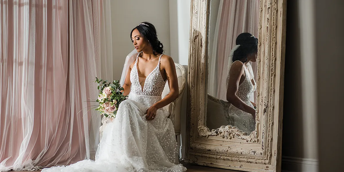 Elegant bridal boutique with spacious viewing areas, showcasing rows of white wedding gowns in a bright, sophisticated...
