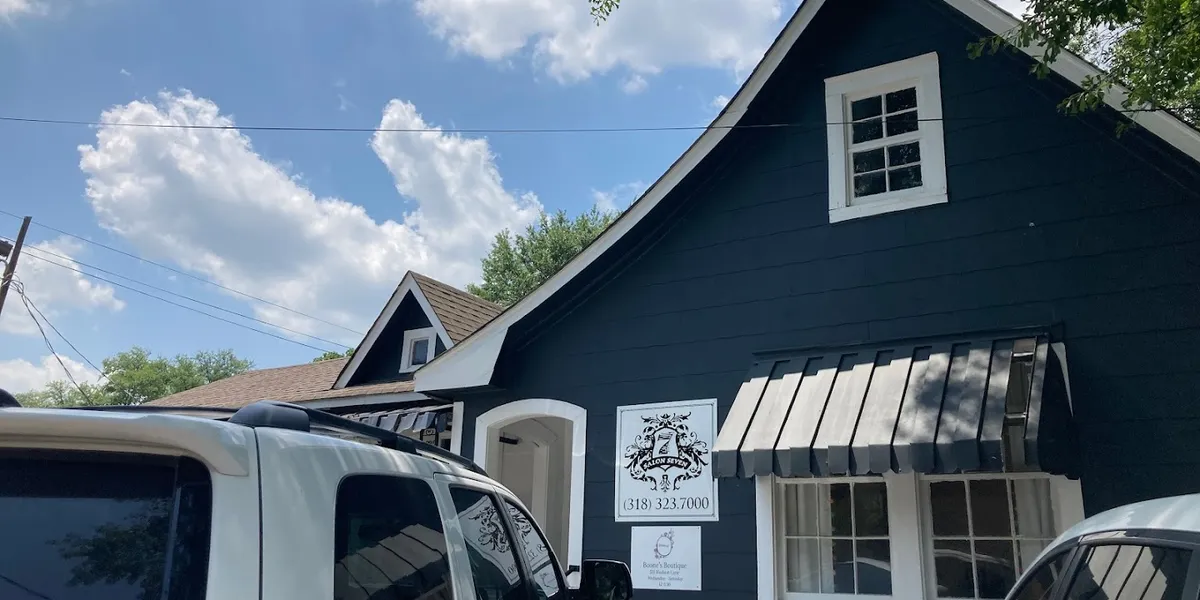 Bright, clean women's boutique with organized displays of graphic tees, jewelry-making station, and ready-to-wear outfit...