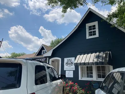 Bright, clean women's boutique with organized displays of graphic tees, jewelry-making station, and ready-to-wear outfit...