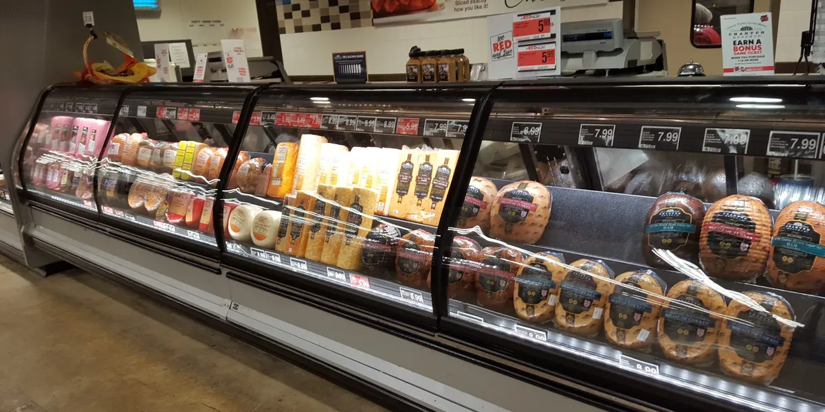 Bright, clean grocery store with well-stocked shelves, a prominent bakery counter, and fresh produce displays at...