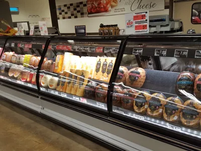 Bright, clean grocery store with well-stocked shelves, a prominent bakery counter, and fresh produce displays at...