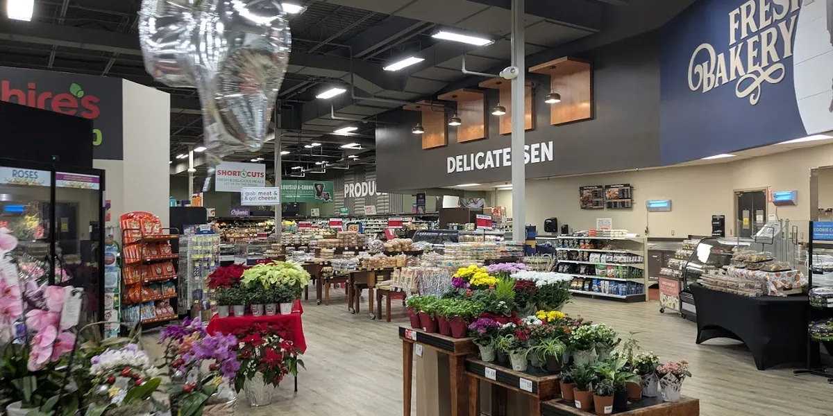 Bright, well-organized grocery store with clean aisles, stocked shelves, and an inviting bakery counter featuring custom...