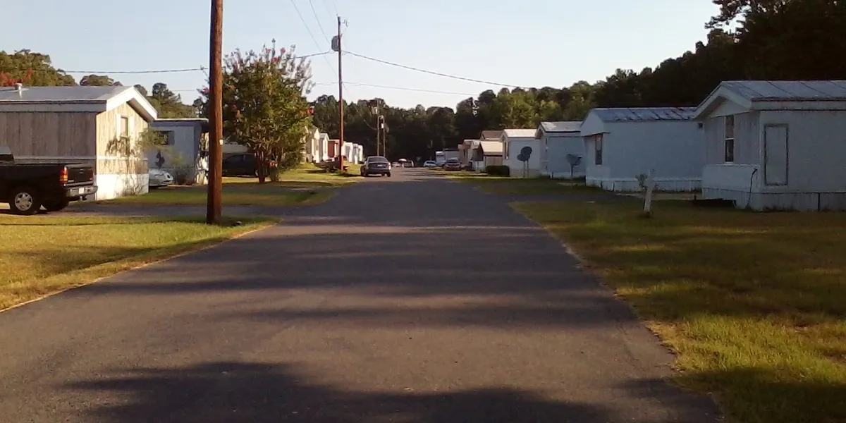 Neatly arranged mobile homes with dedicated parking spaces at Southern Living Village, showcasing a serene,...