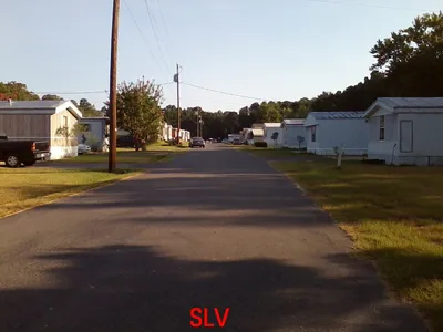 Neatly arranged mobile homes with dedicated parking spaces at Southern Living Village, showcasing a serene,...