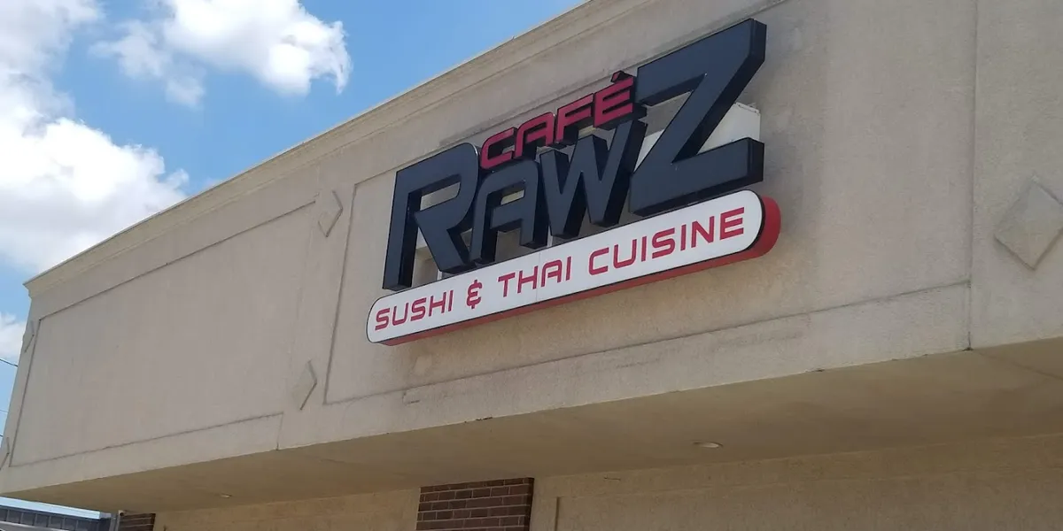 Clean Thai restaurant interior with dining tables, featuring a sushi bar where chefs prepare specialty rolls like the...