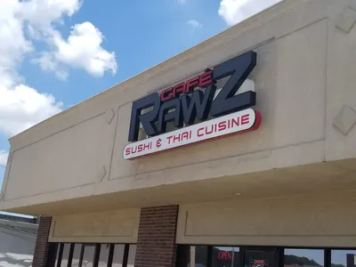 Clean Thai restaurant interior with dining tables, featuring a sushi bar where chefs prepare specialty rolls like the...