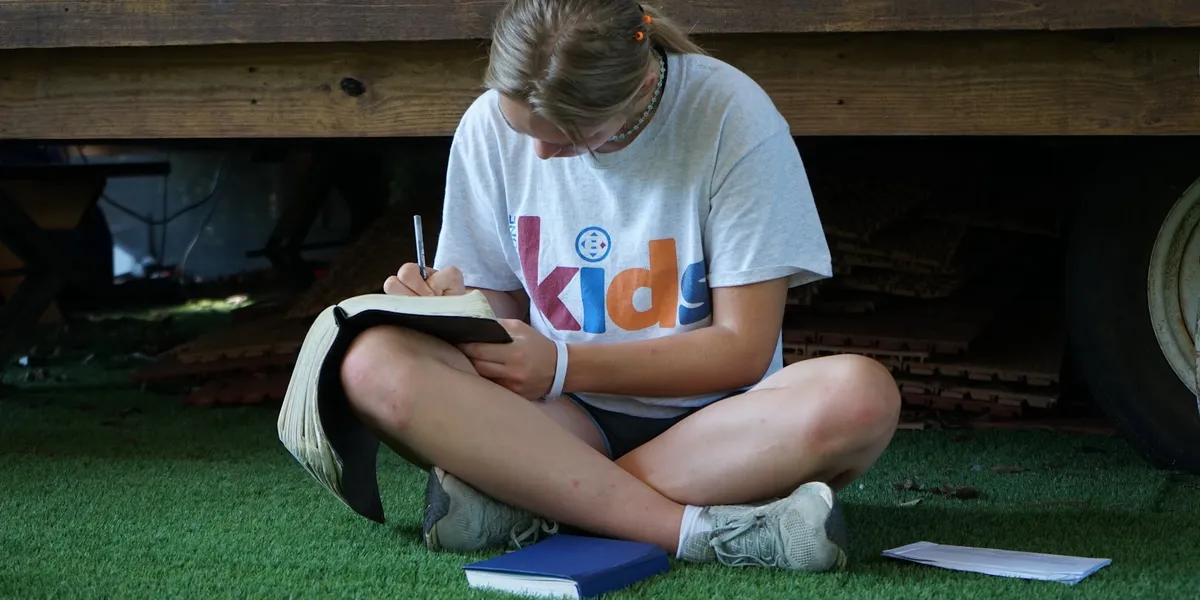 Wooded retreat center with rustic cabins, outdoor swimming pool, and gathering spaces around fire pits nestled in the...