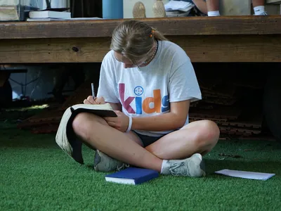 Wooded retreat center with rustic cabins, outdoor swimming pool, and gathering spaces around fire pits nestled in the...