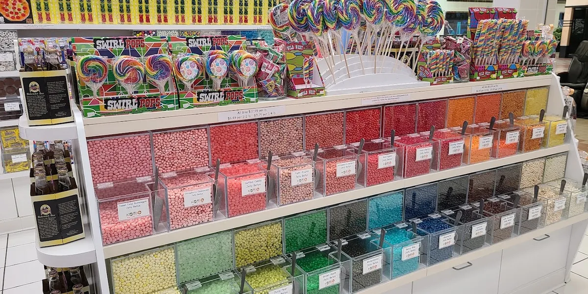 Colorful candy shop in Pecanland Mall with neatly organized displays of exotic and traditional sweets, staffed by smiling...