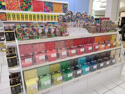 Colorful candy shop in Pecanland Mall with neatly organized displays of exotic and traditional sweets, staffed by smiling...