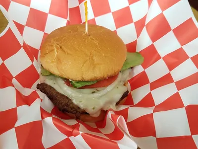 Bright church-based cafe with bistro tables arranged in an intimate dining space, serving homestyle American lunch fare...