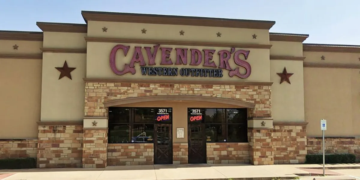 Spacious western outfitter store displaying rows of boots, western apparel, and accessories with rustic decor at...