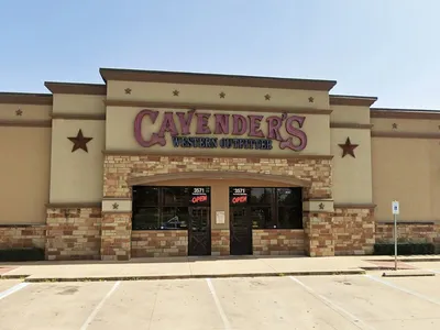 Spacious western outfitter store displaying rows of boots, western apparel, and accessories with rustic decor at...