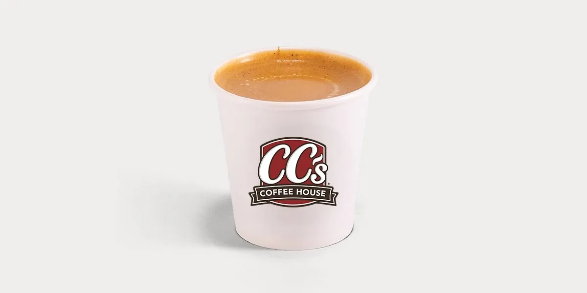 Bright coffee shop interior with counter service, outdoor seating area, and drive-thru window, bustling with morning...