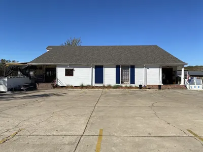 Compact neighborhood market with well-stocked shelves of groceries, prepared foods, and beverages in a bright,...