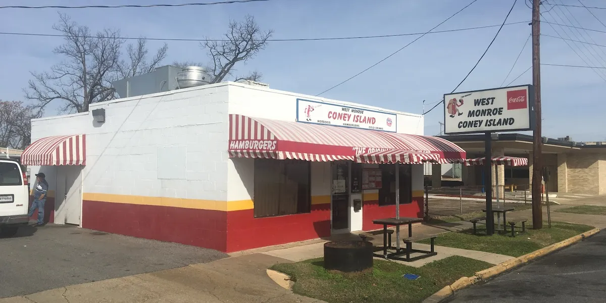 Small, nostalgic diner with vintage car tags and sports photos adorning walls, cozy seating, and classic American comfort...