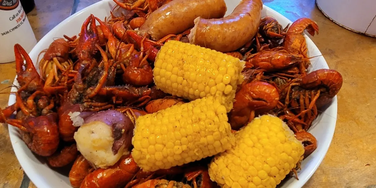 Bustling seafood restaurant with tables of steaming crawfish platters where locals gather weekly during the seasonal...