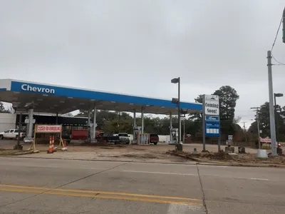 Bright convenience store interior with deli counter serving fresh sandwiches and wraps, featuring coffee station and...