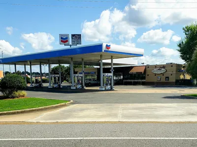 Bright cafe counter inside a credit union building with coffee equipment, display case of baked goods, and order pickup area.