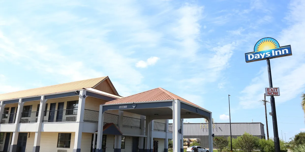 Roadside Days Inn hotel with parking lot, showing the two-story exterior structure situated just off the highway near...