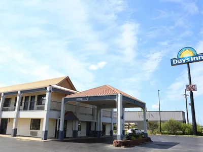 Roadside Days Inn hotel with parking lot, showing the two-story exterior structure situated just off the highway near...