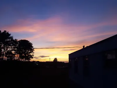Rows of clean, maintained mobile homes at Deer Run Community with paved roads, parking spaces, and interstate visible in...