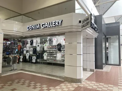 Modern clothing boutique with neatly arranged trendy apparel displays, bright lighting, and a youthful atmosphere in...