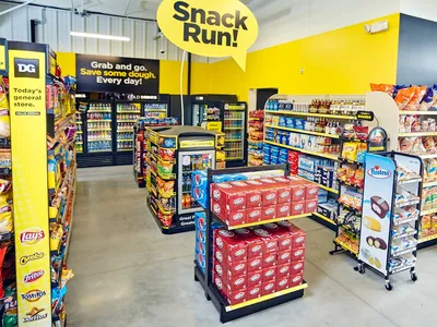 Compact dollar store with narrow aisles and warehouse-style inventory boxes, offering basic grocery essentials in a...
