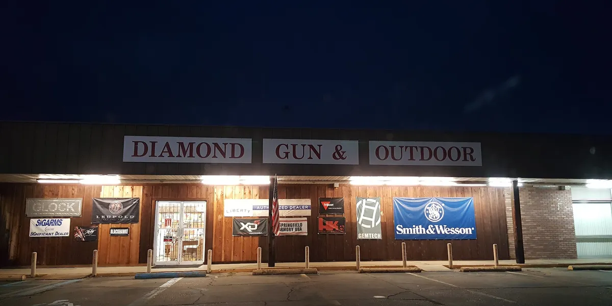 Well-stocked gun display cases at Diamond Gun & Outdoor with various firearms arranged by type, staffed by attentive...