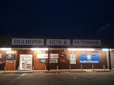 Well-stocked gun display cases at Diamond Gun & Outdoor with various firearms arranged by type, staffed by attentive...
