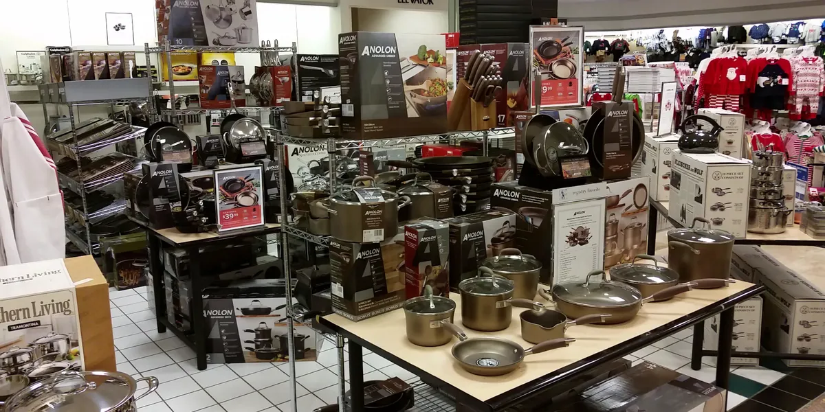 Multi-level Dillard's department store with bright lighting, organized clothing displays, and dedicated sections for...