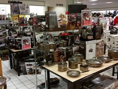 Multi-level Dillard's department store with bright lighting, organized clothing displays, and dedicated sections for...