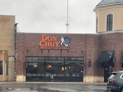 Colorful Mexican restaurant interior with bar area serving specialty margaritas and daiquiris, featuring both indoor and...
