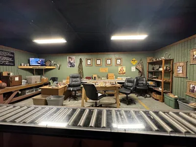 Merchandise-filled warehouse store with Duck Dynasty branded products, featuring rustic decor and potential areas for fan...